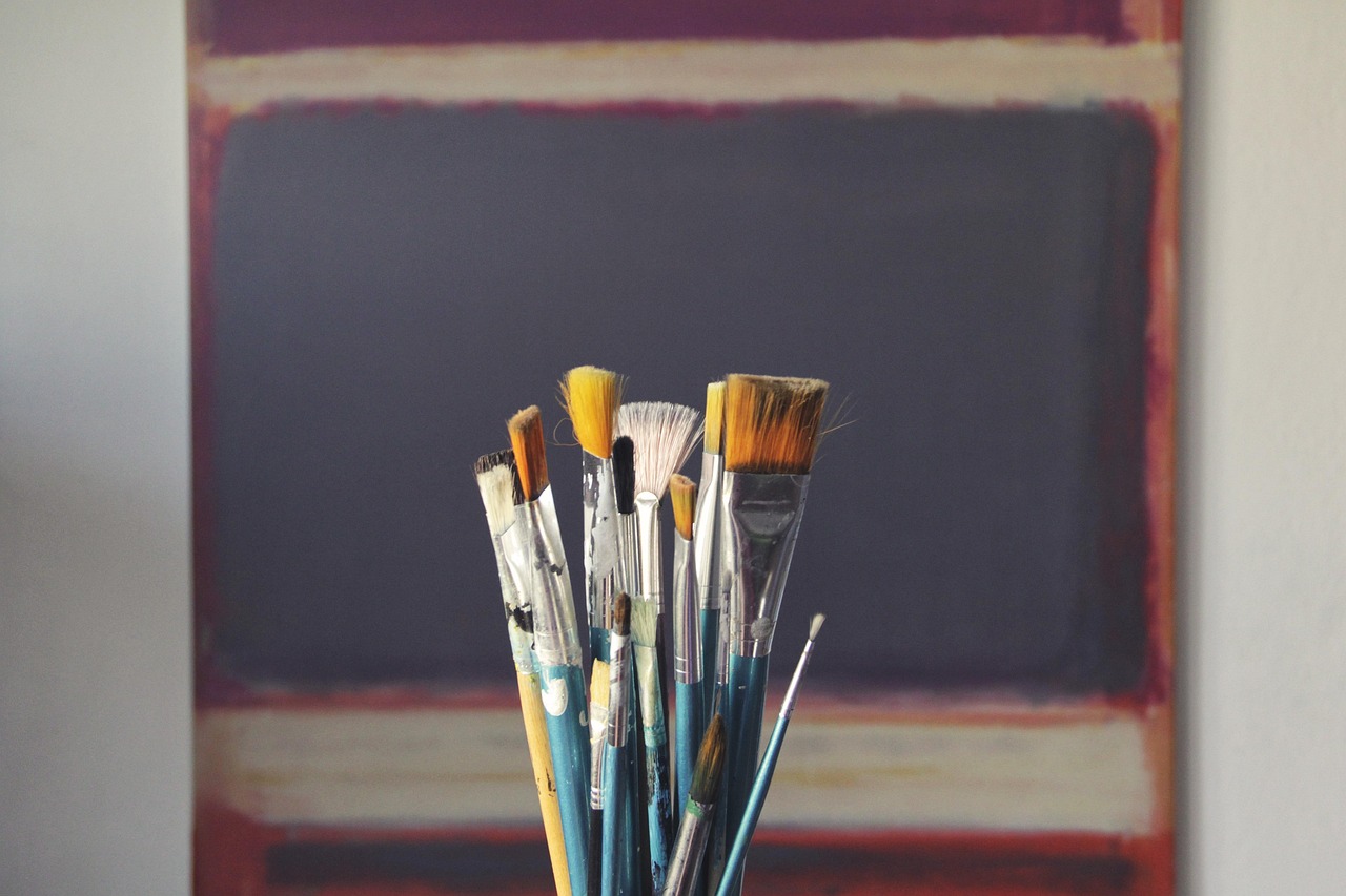 Kleurrijke canvas wandkunst tegen bakstenen muur.